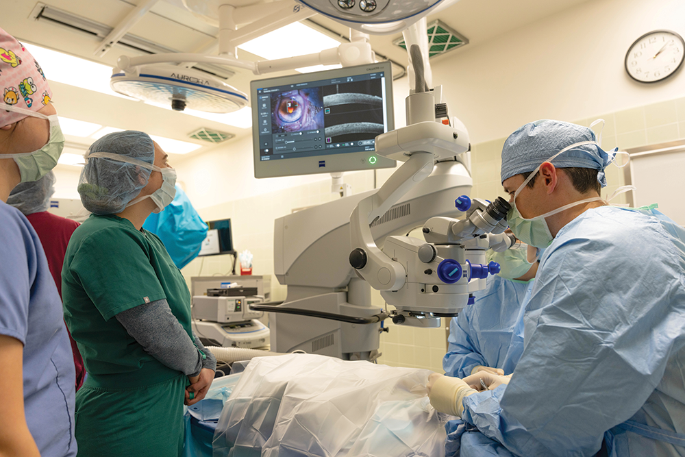 Residents and students (left) observe an ophthalmic surgery being conducted with the assistance of a new microscope.