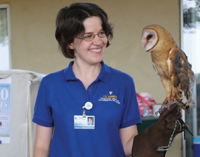 Julie Cotton is pictured with Ember, a barn owl who came to the center in 2018 after suffering broken bones in her left wing when the tree containing her nest was cut. After she was deemed non-releasable, Ember was trained to the glove and helps educate people about raptors as a form of organic pest control. 