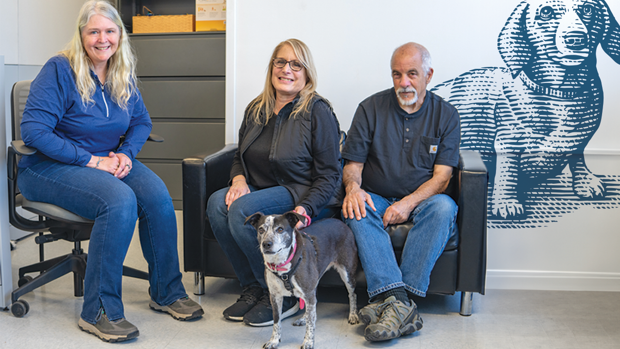A vet and clients with a dog in a room.