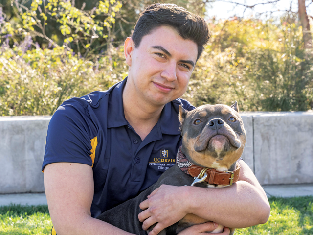 Diego Roque Aguayo hugging a dog.